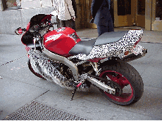 Center right you see a motorcycle found parked on Wall Street. Probably belongs to a famous fashion designer.