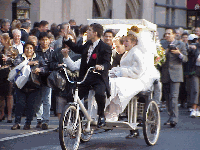 The couple ride through Times Square on this bike as the bride screams to passerby.