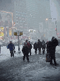 Top left picture you see tourists and New Yorkers making their way through the heavy snow storm on Broadway.