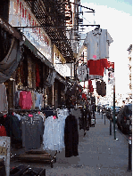 Center right picture you see clothes for sale along the sidewalks in the area known as the Jewish Markets of Orchard Street. Only a year ago the street stayed closed and merchants showed their items outside.  Today everyone is inside the stores.