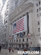 Bottom right picture you see The New York Stock  Exchange and Wall Street in the  smoky haze.  The National Anthem is played through loud speakers as stunned workers try to concentrate on daily life.