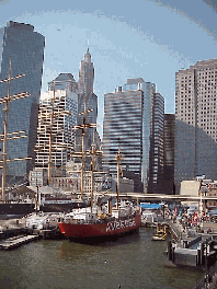 Top right you see the skyline of NYC at South Street Seaport.  The South Street Seaport Historic District encompasses an 11 block area fronting the East River. Here you can visit historic ships, dine and shop in a large mall on the pier.