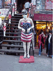 Top right you see the blow up doll outside a store at St. Mark's Place.  This lady is always dressed for the occasion.  Today she's wearing an American flag, gas mask and helmet. We hope she'll lose the head gear and keep the dress.