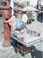 Lady selling merchandise on top of a pushcart