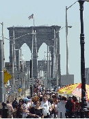 See people walking across the Brooklyn Bridge