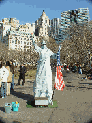 Statue of Liberty mime at Battery Park with the downtown skyline in the background.